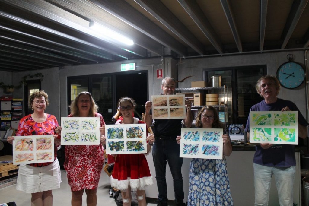 Team members showing their artwork.