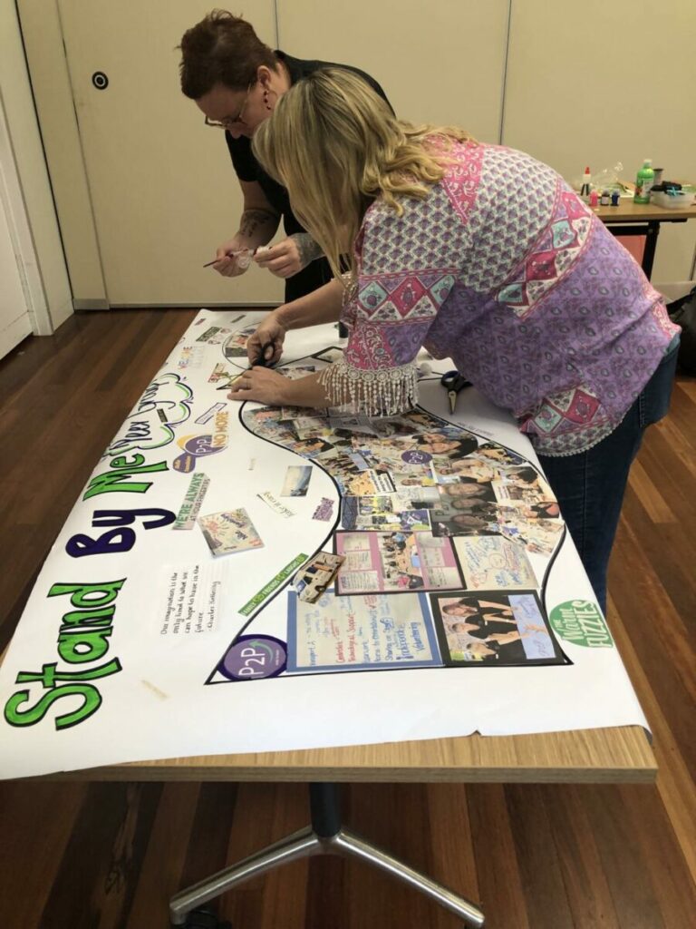 Two people creating a picture timeline of the Stand By Me Project.