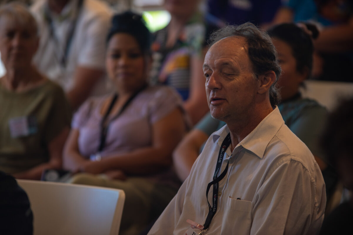 Man with an intellectual disability sitting in the audience at a talk at an advocacy conference